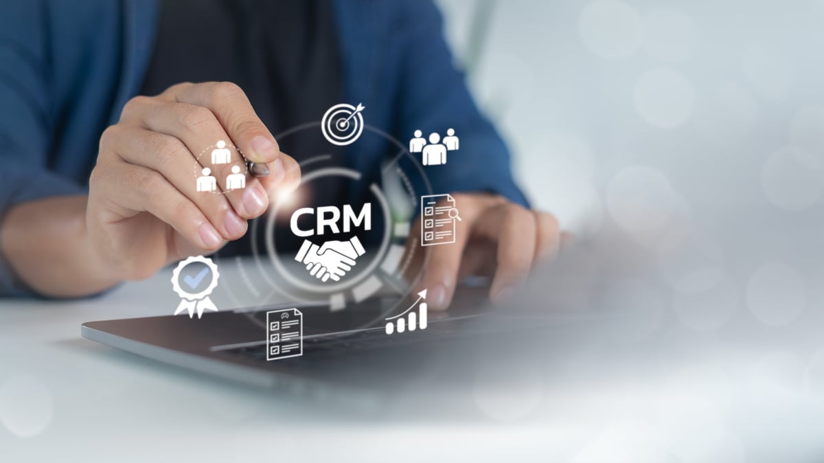 Hand using a laptop with a CRM system for customer relationship management